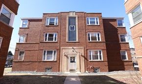 Chicago apartment for rent - A red brick building with a central entrance and windows on all sides.