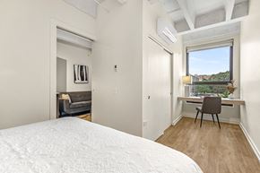 Chicago apartment for rent - a bedroom with a bed and a desk and a window