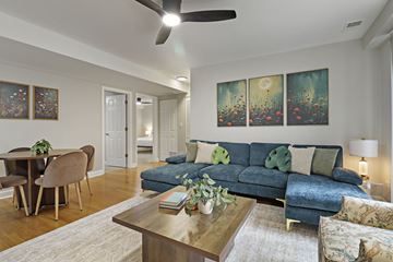 Chicago apartment for rent - A living room with a blue couch and a ceiling fan.