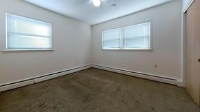 Skokie apartment for rent - A room with a carpeted floor and two windows.