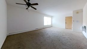 Skokie apartment for rent - A room with a ceiling fan and carpeted floor.