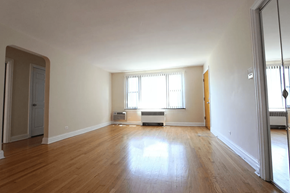 Chicago apartment for rent - A large empty room with wooden floors and white walls.
