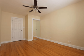 Chicago apartment for rent - A room with a ceiling fan and wooden floors.