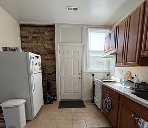 Chicago apartment for rent - A kitchen with a white refrigerator and wooden cabinets.