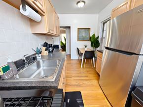 Evanston apartment for rent - A modern kitchen with a stainless steel refrigerator and a dining area with a table and chairs.