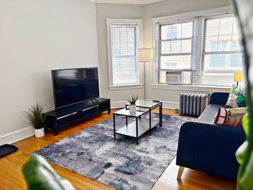Evanston apartment for rent - A living room with a blue couch and a black television.