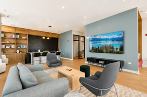 Chicago apartment for rent - A living room with a grey couch, a chair, and a television.