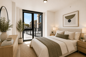 Chicago apartment for rent - A bedroom with a large bed and a view of the city through the window.
