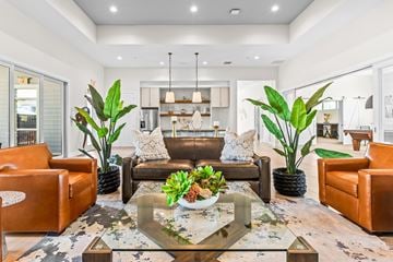 Kissimmee apartment for rent - A modern living room with a glass coffee table and brown leather couches.