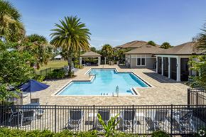 Tavares apartment for rent - A pool surrounded by a black fence and chairs.