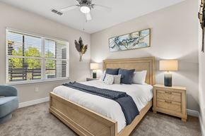 Tavares apartment for rent - A bedroom with a large bed, a ceiling fan, and a painting on the wall.