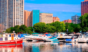 Chicago apartment for rent - A red boat is docked in a marina with other boats and buildings in the background.