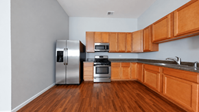 Chicago apartment for rent - A kitchen with wooden cabinets and a stainless steel refrigerator.