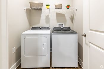 Full size side-by-side washer and dryer in separate room