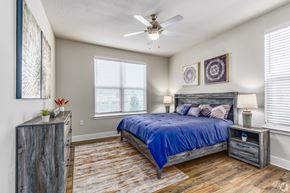 Mount Dora apartment for rent - A bedroom with a bed, nightstand, and a ceiling fan.