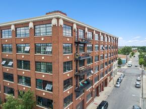 Chicago apartment for rent - a large brick building with many windows and a street