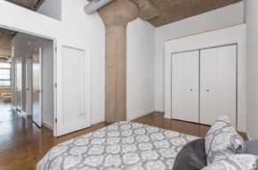 Chicago apartment for rent - a bedroom with a large column in the middle of it and a bed with a
