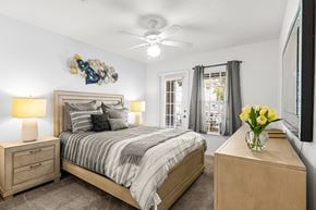 Clermont apartment for rent - A bedroom with a bed, nightstand, and a vase of flowers.