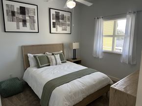 Clermont apartment for rent - A bedroom with a bed, nightstand, and two framed artworks on the wall.