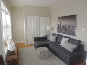 Evanston apartment for rent - a living room with a gray couch and a rug