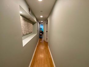 Chicago apartment for rent - A long hallway with a light on the ceiling and a door at the end.