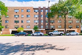Chicago apartment for rent - a large brick building with cars parked in front of it