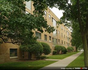 Chicago apartment for rent - A brick building with green trees in front.