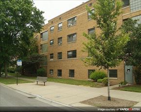Chicago apartment for rent - A brick building with a tree in front of it.