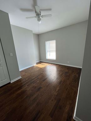 Chicago apartment for rent - an empty living room with wood floors and a ceiling fan