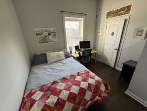 Chicago apartment for rent - A bedroom with a bed, desk, chair, and window.