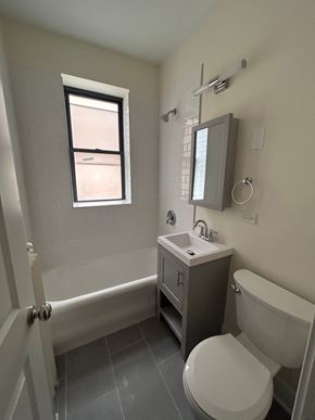 Evanston apartment for rent - A bathroom with a toilet, sink, and bathtub.