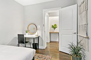 Chicago apartment for rent - a bedroom with a bed and a desk with a mirror