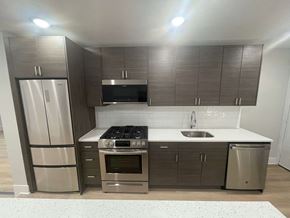 Chicago apartment for rent - an empty kitchen with stainless steel appliances and wooden cabinets