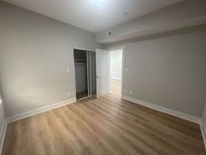 Chicago apartment for rent - a living room with wood flooring and a door to a bedroom