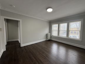 Chicago apartment for rent - A room with a wooden floor and a window.