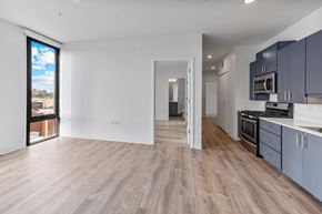 Chicago apartment for rent - A spacious kitchen with a view of the city outside the window.