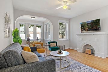 Chicago apartment for rent - A living room with a grey couch and a fireplace.