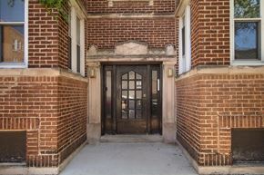 Chicago apartment for rent - A brown door is in a brick building.