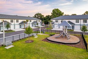 Tavares apartment for rent - A playground with a slide and a swing set in the middle of a grassy area.
