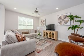 Tavares apartment for rent - A living room with a grey couch, a wooden cabinet, and a ceiling fan.