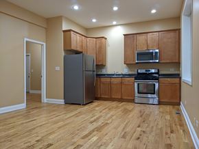 Chicago apartment for rent - A kitchen with wooden floors and a refrigerator.