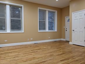 Chicago apartment for rent - A room with wooden floors and two windows.