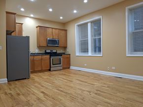 Chicago apartment for rent - A kitchen with wooden floors and a refrigerator.