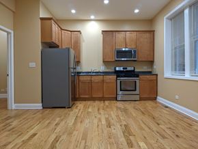 Chicago apartment for rent - A kitchen with wooden floors and a refrigerator.