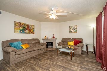 Lafayette apartment for rent - A living room with a brown couch, a fireplace, and a painting on the wall.