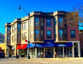Chicago apartment for rent - A row of three buildings with the middle one having a blue awning.