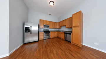 Chicago apartment for rent - A kitchen with wooden cabinets and stainless steel appliances.