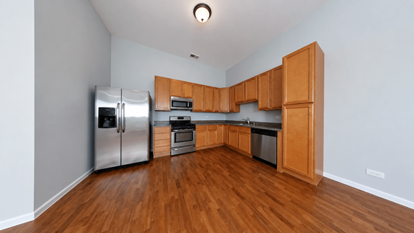 Chicago apartment for rent - A kitchen with wooden cabinets and stainless steel appliances.