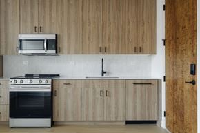 Chicago apartment for rent - A kitchen with wooden cabinets and a microwave above the oven.