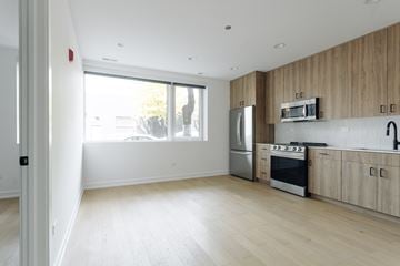 Chicago apartment for rent - A kitchen with wooden cabinets and a stainless steel refrigerator.